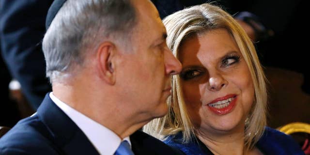 FILE - In this Israeli Dec. 1, 2013. file photo, Prime Minister Benjamin Netanyahu listens to his wife Sara during a meeting with the Roman Jewish Community at the Great Synagogue in Rome. Israeli media say police are questioning the wife of Prime Minister Benjamin Netanyahu over her alleged improper use of public funds. According to multiple media reports, police are looking into claims that Sara Netanyahu used state funds to care for her late father, to pay for private chefs at private family events, and to furnish the Netanyahus' private home near the Mediterranean beach. (AP Photo/Riccardo De Luca, File)