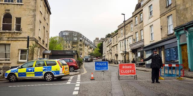 Police divert away traffic from an exclusion zone set up after contractors unearthed a Second World War shell in Bath, England, Friday, May 13, 2016. Hundreds of people have been told to leave homes and businesses in the English city of Bath after a 500-pound (225-kilogram) unexploded World War II shell was found under a school playground. Police evacuated residents for 300 meters (yards) around the device, found during construction work at the disused Royal High School. Some spent the night at a local racecourse. (Ben Birchall/PA via AP) UNITED KINGDOM OUT - NO SALES - NO ARCHIVES