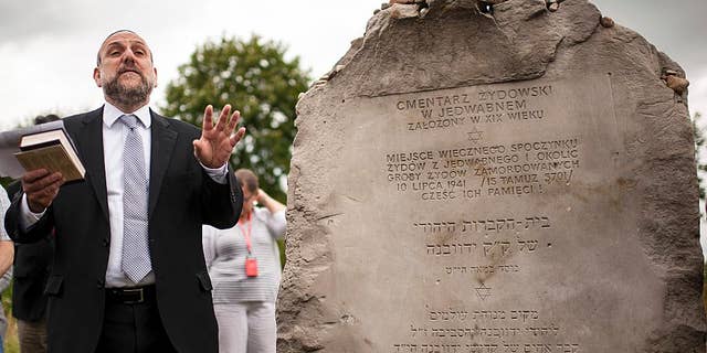 FILE - In this Sunday July 10, 2016 file photo, Poland's chief rabbi Michael Schudrich prays during commemorations marking the 75th anniversary of a massacre of Jews in Jedwabne, Poland. The education minister in Poland’s right-wing government has sparked criticism for appearing to deny Polish responsibility for two massacres of Jews in the 1940s. Anna Zalewska’s comments on Wednesday, July 13 raised questions about the commitment by the populist ruling party, Law and Justice, both to historical truth and to opposing anti-Semitism. (AP Photo/Michal Kosc, file)
