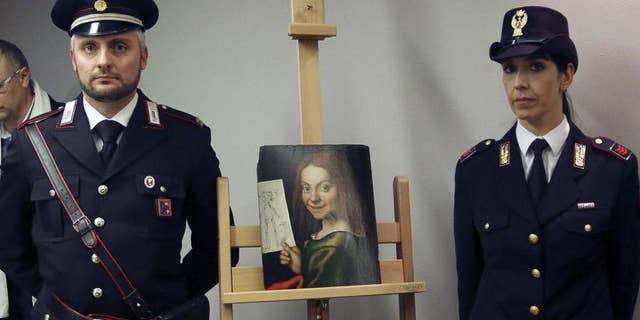 Carabinieri and police officers pose with one of the recovered paintings that were stolen from a Verona museum, at the Verona airport in Italy.