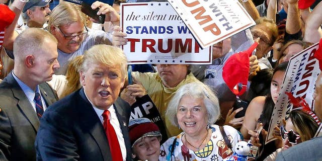 Republican presidential candidate Donald Trump, left, shouts to Secret Service agents that supporter Diana Brest, right, had been waiting in line since 2 a.m. to see the candidate speak at a rally Saturday, June 18, 2016, in Phoenix. (AP Photo/Ross D. Franklin)