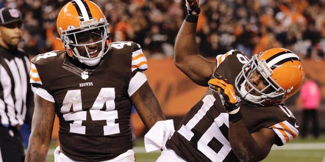 Cleveland Browns wide receiver Andrew Hawkins (16) celebrates running back Ben Tate's (44) 5-yard touchdown run in the fourth quarter of an NFL football game against the Oakland Raiders, Sunday, Oct. 26, 2014, in Cleveland. (AP Photo/Tony Dejak)