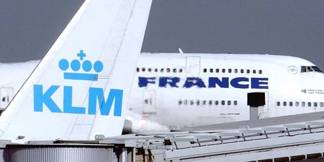 FILE -- In this Sept. 30, 2003 file photo, an Air France jumbo jet rolls behind the tail of a KLM Royal Dutch airliner at Charles de Gaulle airport in Roissy, north of Paris. KLM said Wednesday, Sept. 14, 2016 that it will temporarily suspend flights to and from Cairo in January, citing “economic reasons.” The Royal Dutch Airlines’ statement said the devaluation of the Egyptian pound and restrictions imposed by the country’s central bank on the transfer of foreign currency out of Egypt are behind the decision. (AP Photo/Remy de la Mauviniere, File)