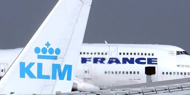 FILE -- In this Sept. 30, 2003 file photo, an Air France jumbo jet rolls behind the tail of a KLM Royal Dutch airliner at Charles de Gaulle airport in Roissy, north of Paris. KLM said Wednesday, Sept. 14, 2016 that it will temporarily suspend flights to and from Cairo in January, citing “economic reasons.” The Royal Dutch Airlines’ statement said the devaluation of the Egyptian pound and restrictions imposed by the country’s central bank on the transfer of foreign currency out of Egypt are behind the decision. (AP Photo/Remy de la Mauviniere, File)