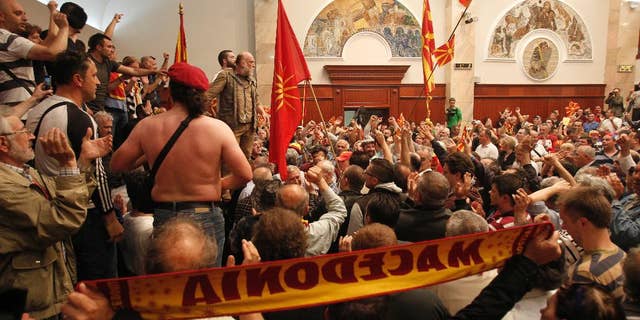 Protestors enter into the parliament building in Skopje, Macedonia, Thursday, April 27, 2017. Scores of protesters have broken through a police cordon and entered Macedonian parliament to protest the election of a new speaker despite a months-long deadlock in talks to form a new government. (AP Photo/Boris Grdanoski)