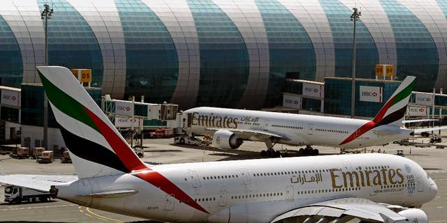 FILE- In this May 8, 2014 file photo, Emirates passenger planes are in use at Dubai airport in United Arab Emirates. The Mideast's biggest airline that touts onboard luxuries like showers and an extensive movie selection is adding something a bit more down-to-earth for those in the back of the plane: charges to pick your own seat ahead of time. The change brings Emirates in line with what many other international carriers have done for years, generating a new revenue stream for the government-owned airline. (AP Photo/Kamran Jebreili, File)