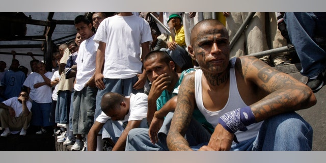 Mara Salvatrucha gang members attend a mass celebrated by Archbishop Luigi Pezzuto, Apostolic Nuncio to El Salvador, and head army and police chaplain Monsignor Fabio Colindres at a prison in Ciudad Barrios, El Salvador, Monday, March 26, 2012. According to Dionisio Aristides Umanzor, known as El Sirra, leader of the Mara Salvatrucha gang, leaders of the Mara Salvatrucha and the Mara 18, El Salvador's two largest street gangs, have reached a truce, reducing the country's homicide rate, one of the highest in the world. (AP Photo/Luis Romero)