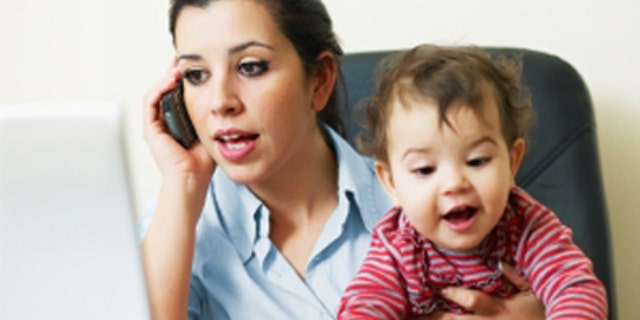 stressed business woman in office, holding her little girl while talking on mobile phone. Vertical shape, Copy space