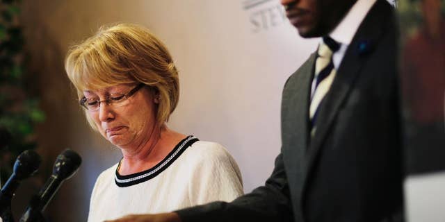 Mary Ann Sherman, left, weeps during a news conference with her attorney Chris Stewart, right, in response to a video showing her son's struggle with police officers Friday, May 20, 2016, in Atlanta. Two deputies yell "Stop fighting!" and "He's got my Taser!" as they repeatedly stun Chase Sherman, handcuffed in the back of a vehicle, commanding him to relax even as he insists "I'm dead," shortly before he stops breathing, body-camera video from the incident shows. The video shows the Nov. 20 incident in the back of an SUV in Coweta County, outside Atlanta. Sherman, 32, of Destin, Florida, was pronounced dead at a hospital later that day.(AP Photo/David Goldman)