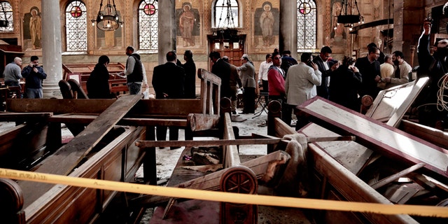 In this Dec. 11, 2016 file photo, security forces examine the scene inside the St. Mark Cathedral in central Cairo, following a bombing that killed dozens of people.