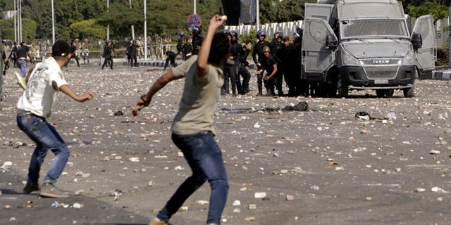 Oct. 20, 2013: Protesters throw stones during clashes with riot police in front of the main offices of Al-Azhar University in Cairo. Egyptian security forces fired bird shot and tear gas to prevent supporters of deposed Islamist President Mohamed Morsi from marching on Sunday to the site of a protest camp at Rabaa al-Adaweya mosque that was destroyed two months ago, a Reuters witness said.