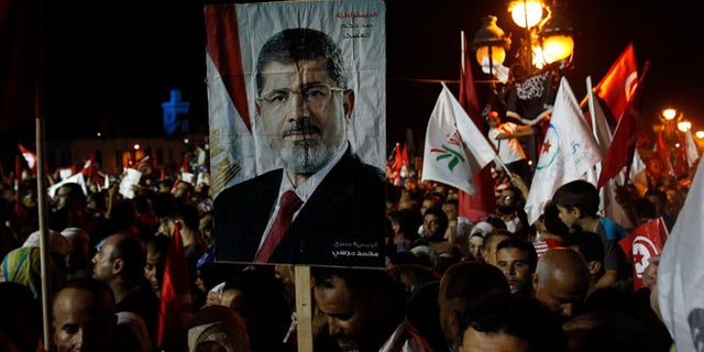 Aug 3, 2013: Supporters of the Islamist Ennahda movement hold a portrait of ousted Egyptian President Mohamed Morsi during a demonstration at Kasbah Square in Tunis.