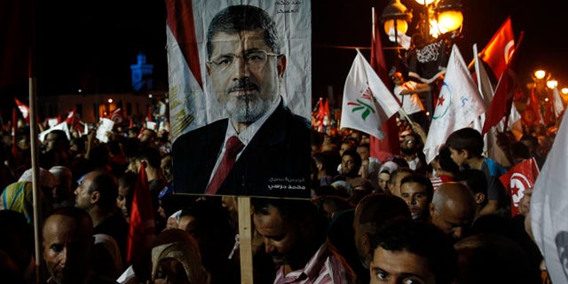 Aug 3, 2013: Supporters of the Islamist Ennahda movement hold a portrait of ousted Egyptian President Mohamed Morsi during a demonstration at Kasbah Square in Tunis.