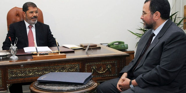 FILE - In this Sunday, July 22, 2012 file photo released by the Egyptian Presidency, Egyptian President, Mohammed Morsi, left, meets with the minister of Water Resources and Irrigation, Hesham Kandil, at the Presidential Palace in Cairo.