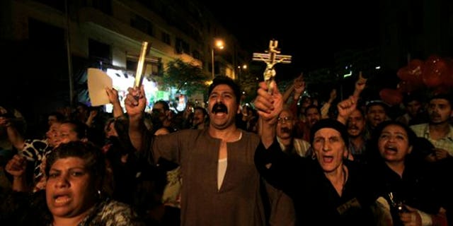 Oct. 4: In this file photo, Egyptian Copts hold Christian crosses and chant slogans as they demonstrate against the sectarian violence, in downtown Cairo, Egypt. In the past few weeks, riots have broken out at two churches in southern Egypt, prompted by Muslim crowds angered by rumors that Christians were building new churches.