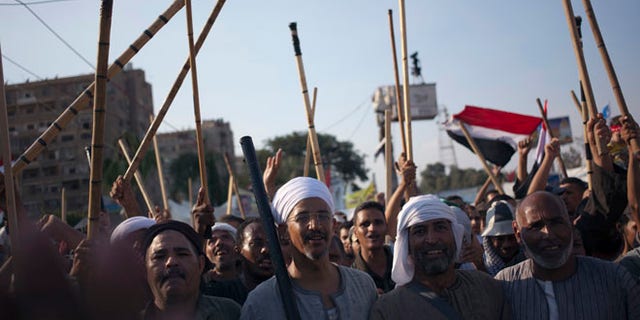Aug. 10, 2013: Supporters of Egypt's ousted President Mohammed Morsi hold up wooden sticks as they participate in a protest outside Rabaah al-Adawiya mosque, where protesters have installed a camp and held daily rallies at Nasr City, in Cairo, Egypt.