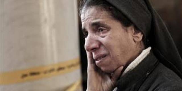 An Egyptian Coptic nun weeps as she looks at damage inside the St. Mark Cathedral in central Cairo, following a bombing in December 2016.