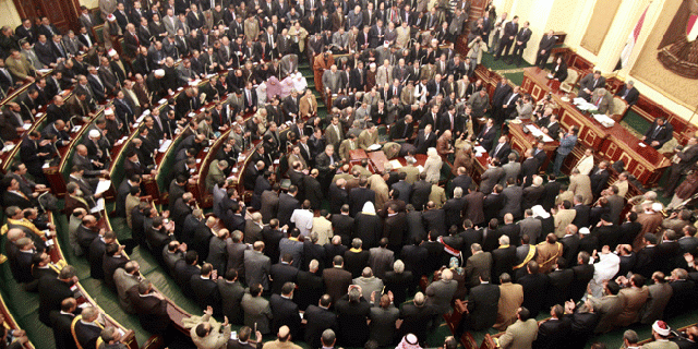 Jan 23, 2012: Members of parliament stand and pray for the souls of the victims who died during the uprising that ousted President Hosni Mubarak during the first Egyptian parliament session after the revolution, in Cairo, Egypt.