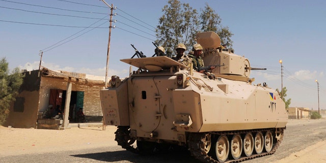 May 21, 2013: In this file photo, Egyptian Army soldiers patrol in an armored vehicle backed by a helicopter gunship during a sweep through villages in Sheikh Zuweyid, northern Sinai, Egypt.