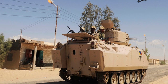 May 21, 2013: In this file photo, Egyptian Army soldiers patrol in an armored vehicle backed by a helicopter gunship during a sweep through villages in Sheikh Zuweyid, northern Sinai, Egypt.