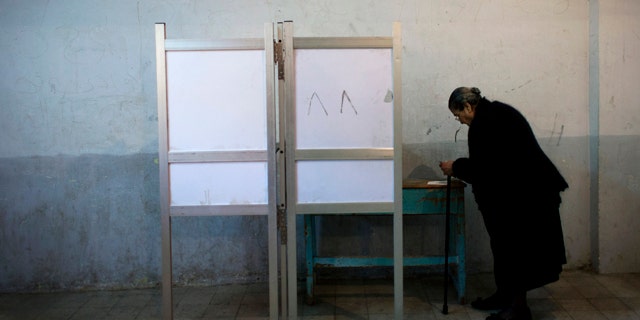 Dec. 15, 2012: An Egyptian woman votes at polling center during a referendum on a disputed constitution drafted by Islamist supporters of President Mohammed Morsi in Cairo.