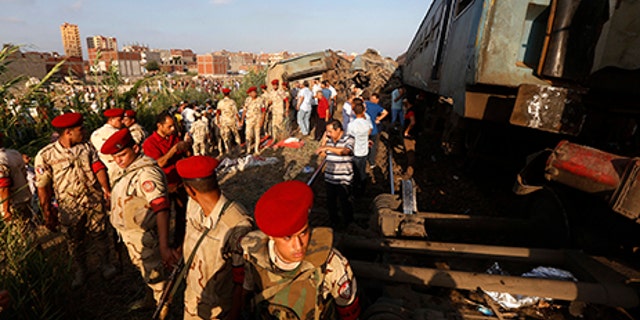 Army attend the scene of a train collision just outside Egypt's Mediterranean port city of Alexandria, Friday.
