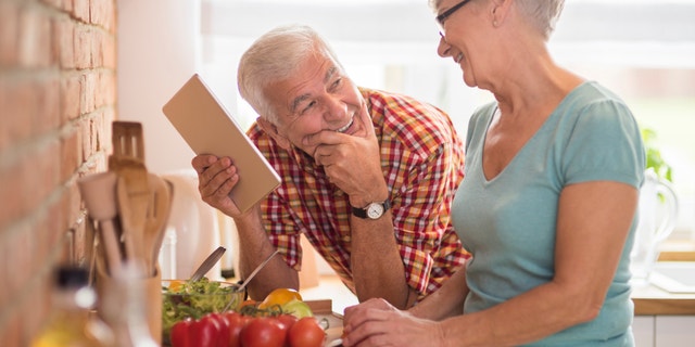 Modern senior couple spending time in the kitchen