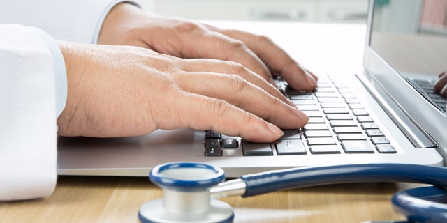 Close up of doctor's hand at computer typing