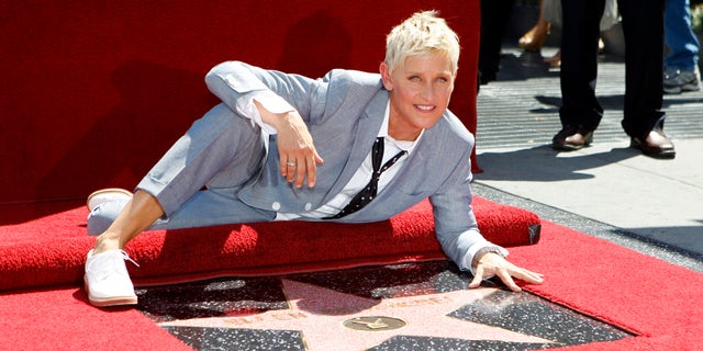 Television personality Ellen DeGeneres poses by her star after it was unveiled on the Walk of Fame in Hollywood, California September 4, 2012. REUTERS/Mario Anzuoni (UNITED STATES - Tags: ENTERTAINMENT) - RTR37HN3