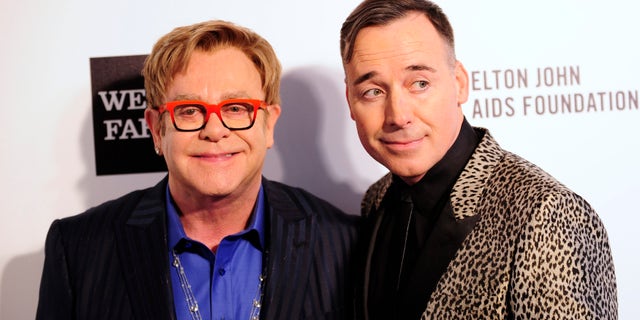 Elton John (L) and David Furnish arrive at the 2014 Elton John AIDS Foundation Oscar Party in West Hollywood, California.