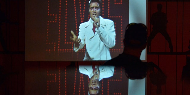 File photo - A man watches a video of Elvis Presley performing during the grand opening of "Elvis Presley's Memphis", a $45 million, state-of-the-art entertainment and museum complex, in Memphis, Tennessee, U.S., March 2, 2017. (REUTERS/Brandon Dill)