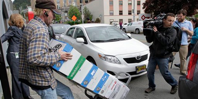 A worker rolls a cart with boxes containing thousands of pages of Sarah Palin's emails from her time as Alaska's governor June 10 in Juneau, Alaska.