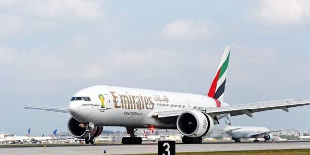 An Emirates aircraft taxis down the runway.