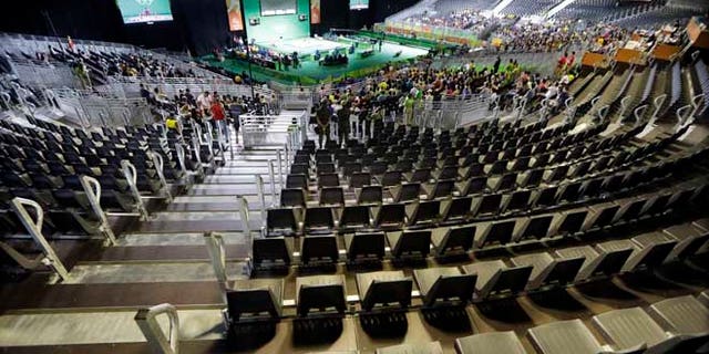 The majority of the spectator seats are empty during the men's 56kg weightlifting competition at the 2016 Summer Olympics in Rio de Janeiro, Brazil, Sunday, Aug. 7, 2016. (AP Photo/Mark Humphrey)