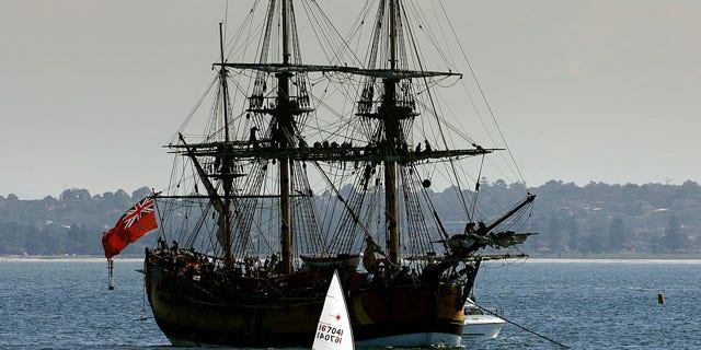 Crew members sit atop the masts of a replica of the famous 18th century ship The Endeavour in Botany Bay file photo.