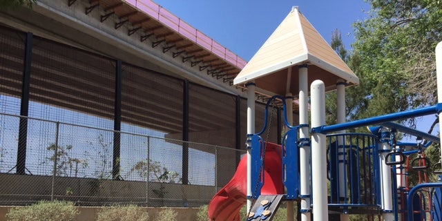 The border fence sits above a children's playground in downtown El Paso.