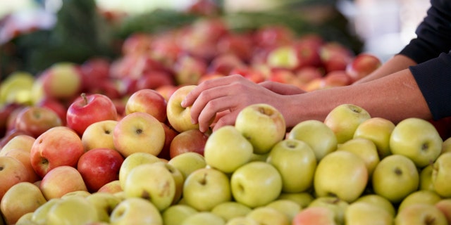 In this photo taken Oct. 5, 2014, apples are displayed at a farmers market in Arlington, Va. A common pesticide used on citrus fruits, almonds and other crops would be banned under a proposal announced Friday by the Environmental Protection Agency. The proposal would prohibit use of chlorpyrifos, a widely used insecticide that is sprayed on a variety of crops including oranges, apples, cherries, grapes, broccoli and asparagus. (AP Photo/J. Scott Applewhite)