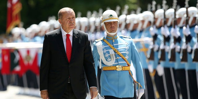Turkey's President Recep Tayyip Erdogan inspects an honour guard as he arrives at the parliament in Ankara, Turkey to attend opening session of the new parliament in Ankara, Turkey, Saturday, July 7, 2018.
