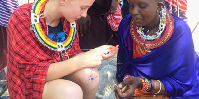 Dolan family spending time with the locals, learning how to make bracelets in Tanzania.