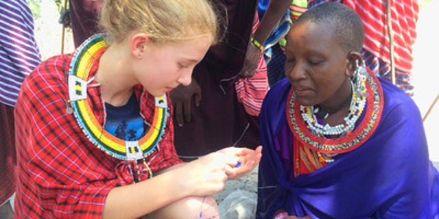Dolan family spending time with the locals, learning how to make bracelets in Tanzania.