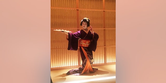 A geisha performs a traditional dance.
