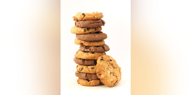 Stack of several chocolate and hazelnut cookies with chocolate chips and cranberies