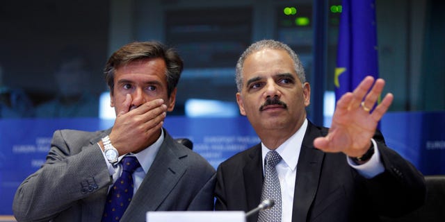 Spanish MEP Juan Fernandez Aguilar, left, looks on as United States Attorney General Eric Holder, right, speaks during a session at the European Parliament in Brussels on Tuesday, Sept. 20, 2011.