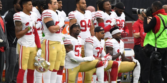 Eric Reid (35) kneels during the national anthem with San Francisco 49ers teammates.