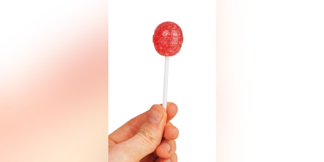 Man hand with lollipop isolated on white background