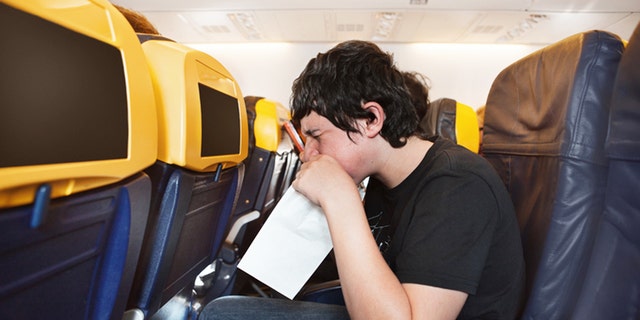 Boy getting sick in an airplane