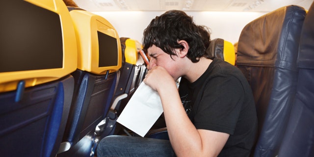 Boy getting sick in an airplane