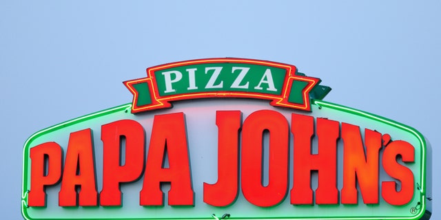 Huntsville, Alabama, USA - June 14, 2011: Close up of illuminated neon Papa Johns Pizza Sign at sunset with copy space above. Sign located on University Drive in Huntsville, Alabama. Horizontal composition.