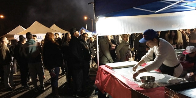 This April 22, 2017 photo shows a man preparing a large crepe used in a Burmese dish sold at the Queens Night Market in New York City's Corona, Queens, neighborhood.