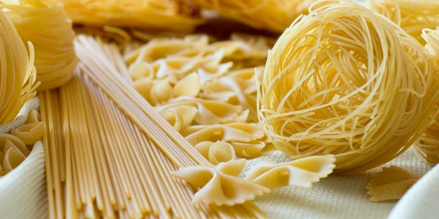 different types of raw pasta on a tablecloth